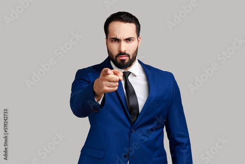 Fotografie Strict bearded man noticing and pointing finger to camera, accusing with serious bossy face, making choice, wearing official style suit