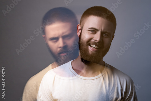 Portrait of two-faced man in calm serious and happy expression. Different emotion inside and outside mood. Internally suffering, dissociative identity disorder. Double exposure. indoor, studio shot