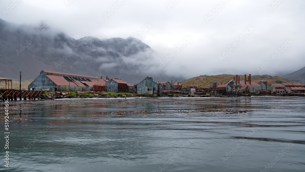Obraz premium Derelict, rusted buildings along the shore at the old whaling station at Leith Harbor, South Georgia Island