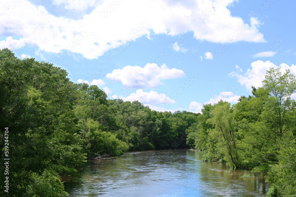 river water tree lined waterway clouds blue sky tranquil riparian countryside rural landscape