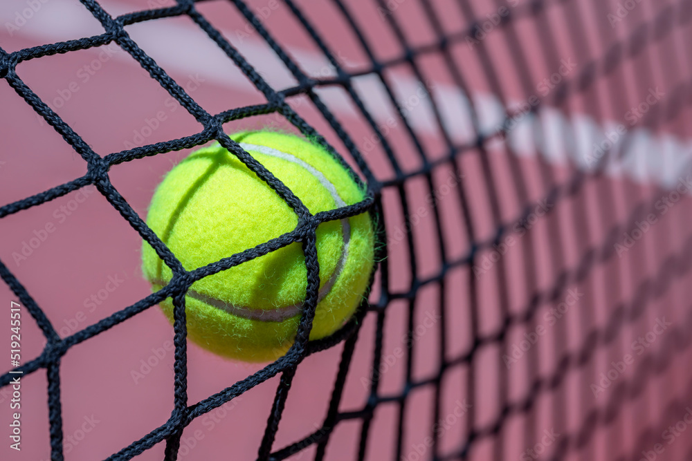 CLOSEUP OF A TENNIS OR PADEL BALL HITTING THE NET.