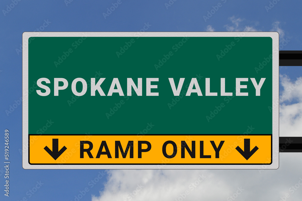 Spokane Valley logo. Spokane Valley lettering on a road sign. Signpost at entrance to Spokane Valley, USA. Green pointer in American style. Road sign in the United States of America. Sky in background