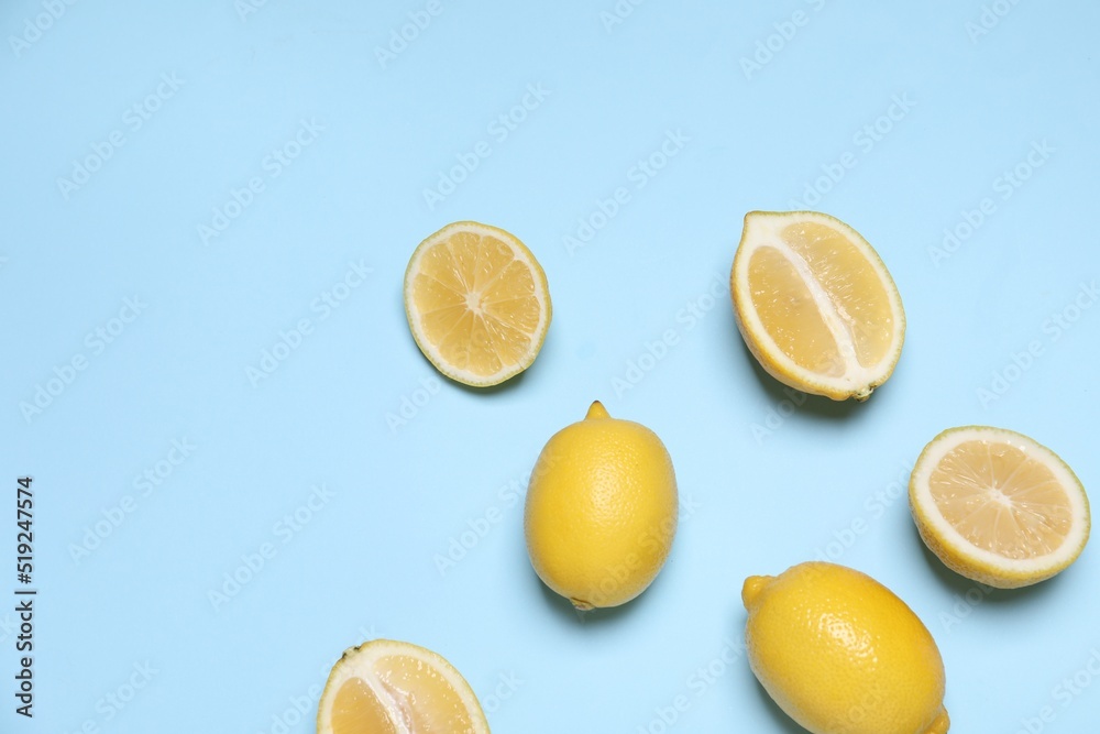 Many fresh ripe lemons on light blue background, flat lay. Space for text