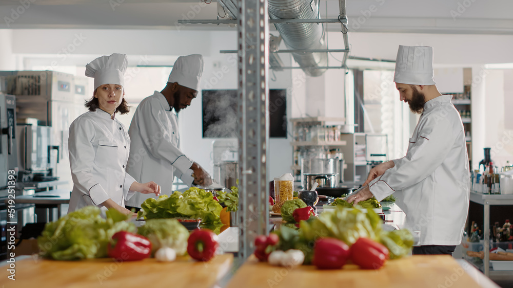 Authentic portrait of female chef working in professional gourmet kitchen, cooking food recipe with fresh ingredients. Woman with arms crossed preparing culinary dish meal for dinner menu. Authentic portrait of female chef working in professional gourmet kitchen, cooking food recipe with fresh ingredients. Woman with arms crossed preparing culinary dish meal for dinner menu.
