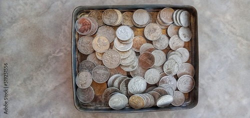 Indonesian money rupiah coins (uang receh) on tiled floor background. top view photo