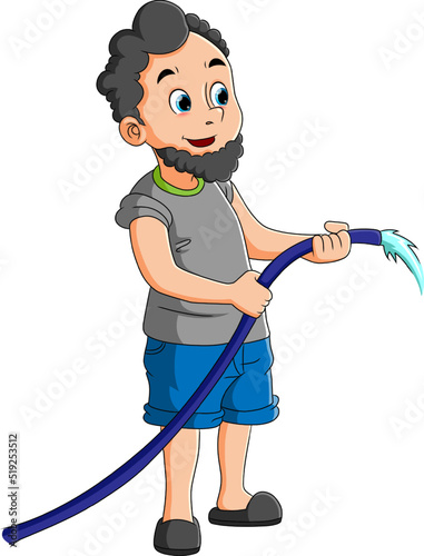 The man is watering the garden and the park with the water from the hose