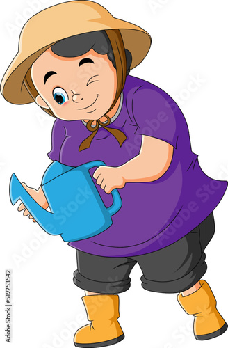The happy farmer woman is watering the plant with the fresh water