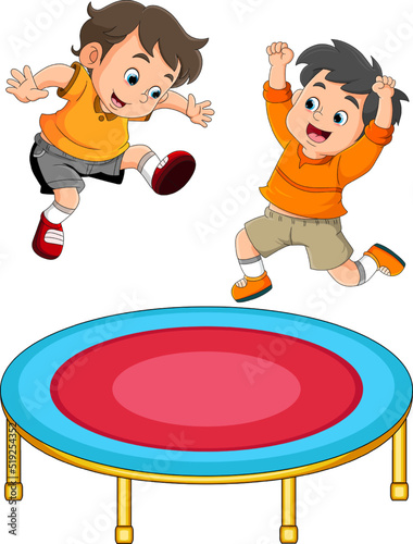The twin boys is jumping together on the trampoline