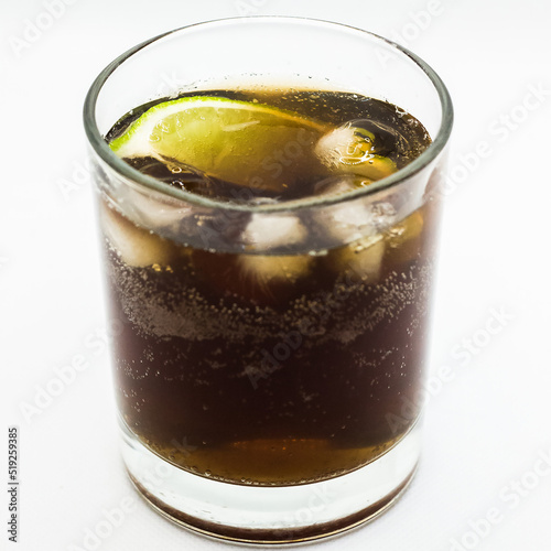 Alcoholic cocktail Cuba Libre in a glass on a white background