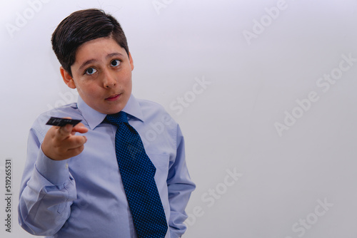 A little businessman boy dressed in a suit and tie handing his card to someone. Little boy pretending to be an important businessman. photo