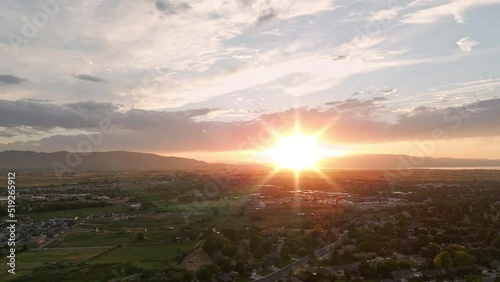 Flying towards sunset over Spanish Fork Utah viewing city and farmland below. photo