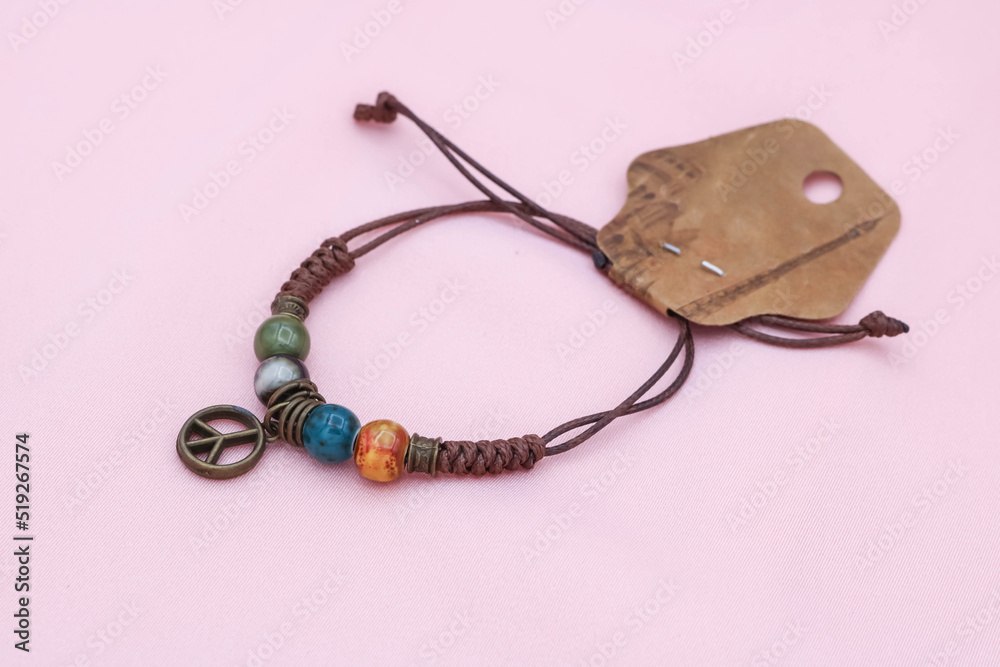 DIY style rope bracelet on a pink background.