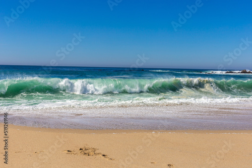 A view on Pacific ocean coast with blue sky and water and waves © Polina Korchagina