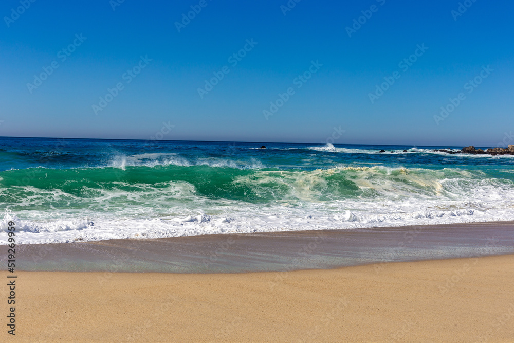 A view on Pacific ocean coast with blue sky and water and waves