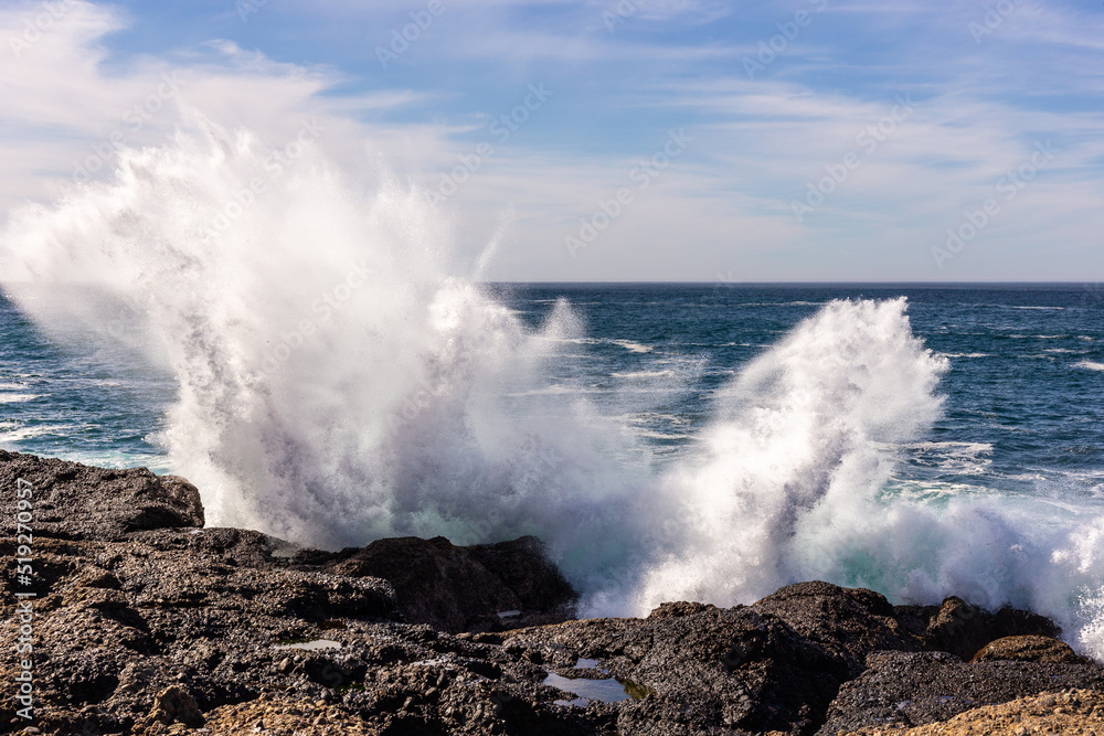 A view on Pacific ocean coast with blue sky and water and waves