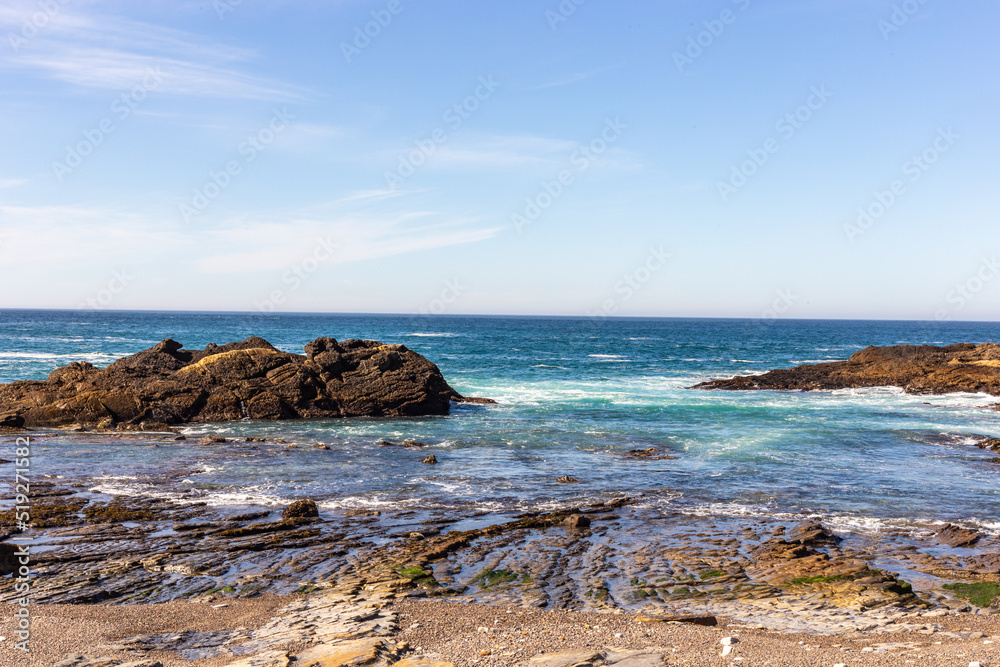 A view on Pacific ocean coast with blue sky and water and waves