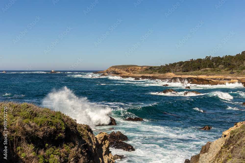 A view on Pacific ocean coast with blue sky and water and waves