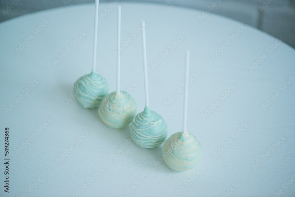 cake pops on a stick on a white background, lying on the table cake pops on a stick on a white background, lying on the table