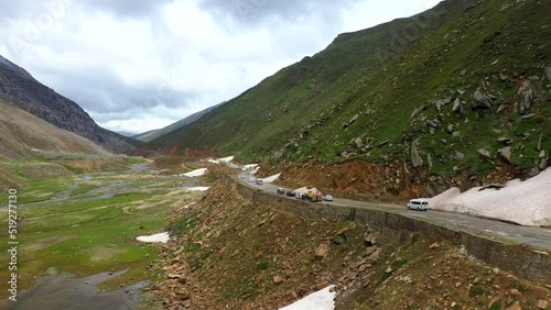 Drone shot of the Babusar Pass mountain pass in Pakistan, with a few vehicles on the road in the Kaghan Valley, descending towards vehicles photo