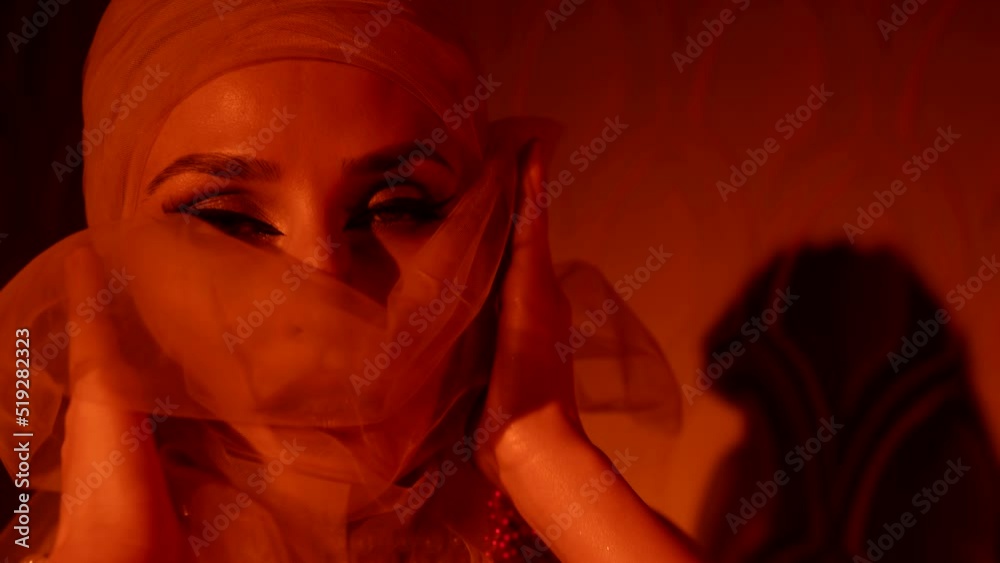 portrait of a woman in a turban. she moves hands beautifully. close-up. red light portrait of a woman in a turban. she moves hands beautifully. close-up. red light