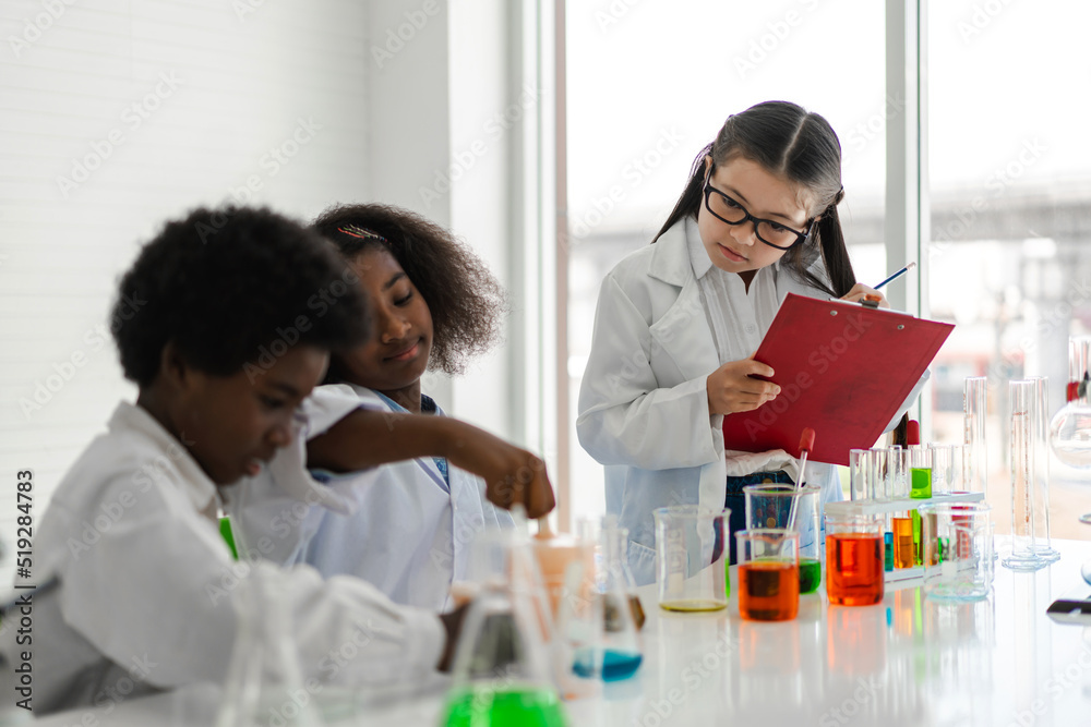 Group of teenage student learn with teacher and study doing a chemical experiment and holding test tube in hand in the experiment laboratory class on table at school.Education concept Group of teenage student learn with teacher and study doing a chemical experiment and holding test tube in hand in the experiment laboratory class on table at school.Education concept