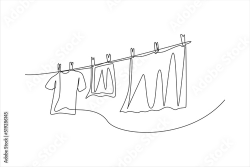 Continuous one line drawing clean clothes hanging on a rope. Laundry service concept. Single line draw design vector graphic illustration.