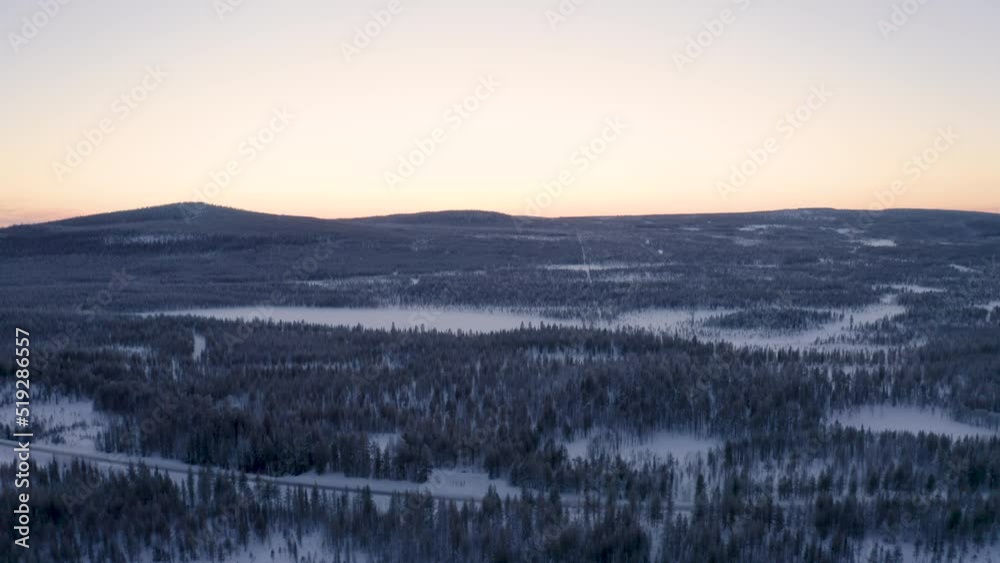 Aerial view looking down over Scandinavian woodland landscape tilt up reveal snow covered mountain range wilderness Aerial view looking down over Scandinavian woodland landscape tilt up reveal snow covered mountain range wilderness