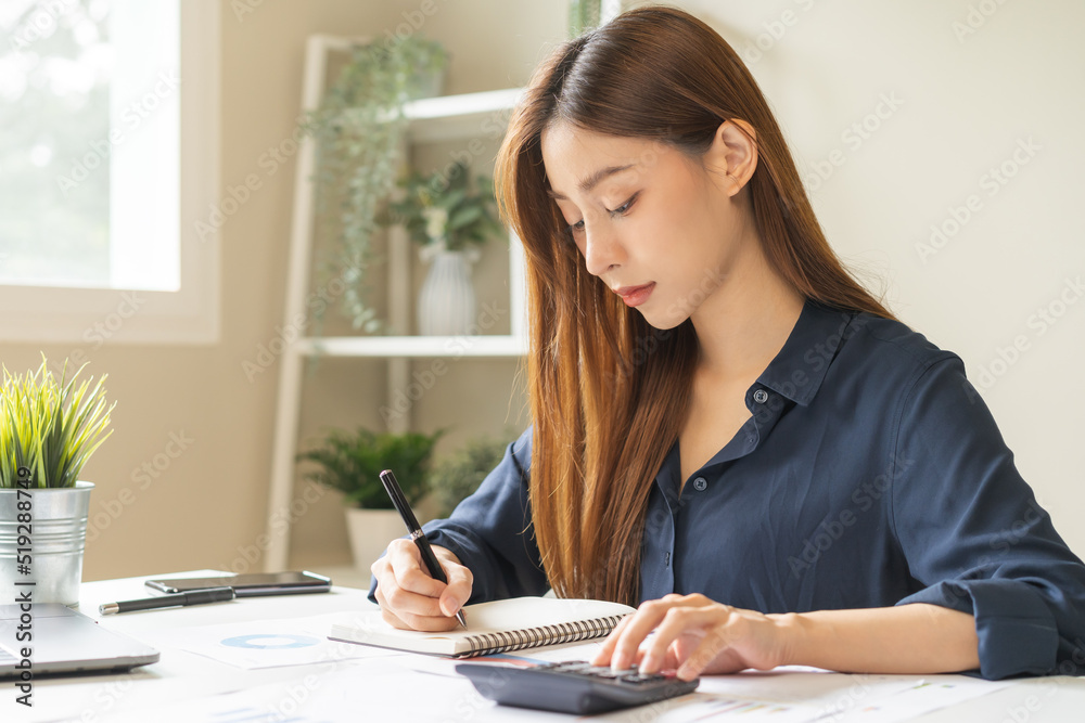 Account finance, attractive asian young business woman hand use calculator for calculate budget, cost and income of company from reports paperwork, plan spend money expenses, working on desk at home. Account finance, attractive asian young business woman hand use calculator for calculate budget, cost and income of company from reports paperwork, plan spend money expenses, working on desk at home.