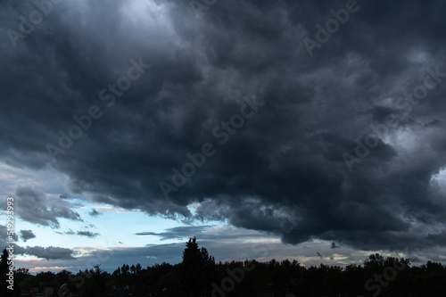 Stormy sky with trees in the forest silhouetes