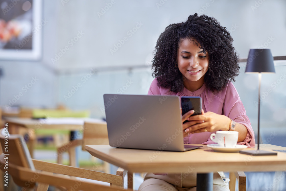 Portrait of a businesswoman casually dressed looking at the phone while sitting in a coffee shop and working. Portrait of a businesswoman casually dressed looking at the phone while sitting in a coffee shop and working.