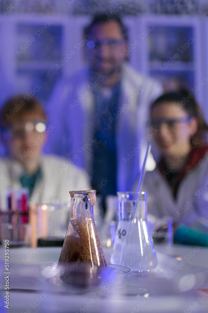 Science students with teacher doing chemical reaction experiment in the laboratory at university.