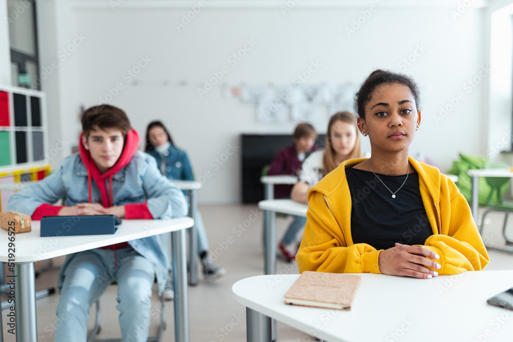 High school students paying attention in class, sitting in their desks and writing notes, back to school concept. High school students paying attention in class, sitting in their desks and writing notes, back to school concept.