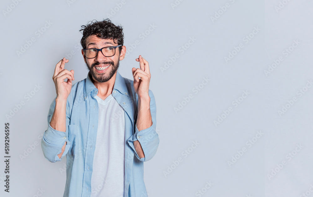 Concept of positive person making a wish and crossing his fingers on isolated background. Positive people smiling making a wish while crossing his fingers. Happy man making a wish crossing his fingers Concept of positive person making a wish and crossing his fingers on isolated background. Positive people smiling making a wish while crossing his fingers. Happy man making a wish crossing his fingers
