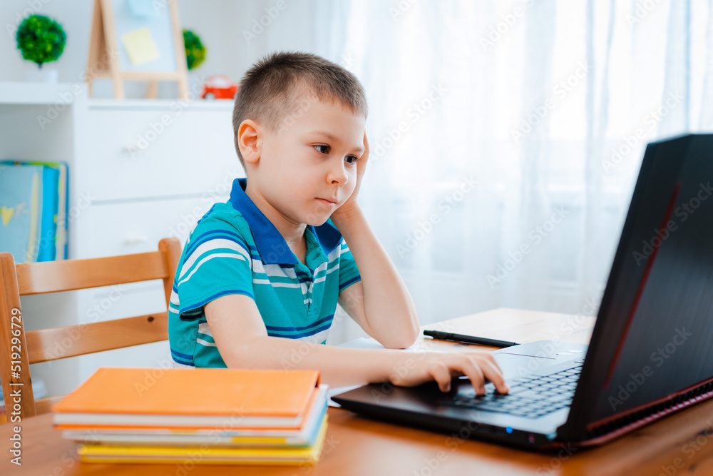 Distance learning online education. A schoolboy boy studies at home and does school homework. A home distance learning Distance learning online education. A schoolboy boy studies at home and does school homework. A home distance learning