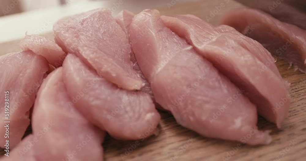 The cook cuts turkey meat on a wooden board. The cook cuts turkey meat on a wooden board.