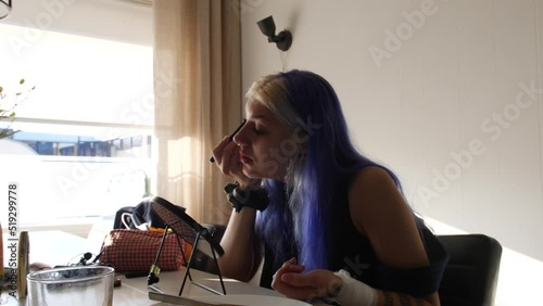 Street Party Girl Applying Makeup In The Room In Daylight. medium shot photo