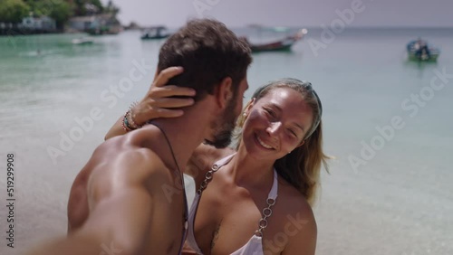 A close up shot of a couple kissing each other while standing on a beautiful beach. Romantic video