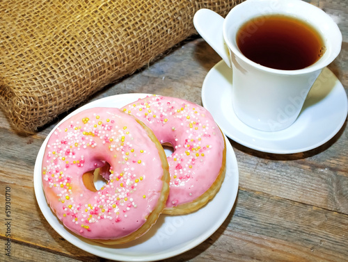 Sweet tasty donuts with sprinkling and fragrant tea.