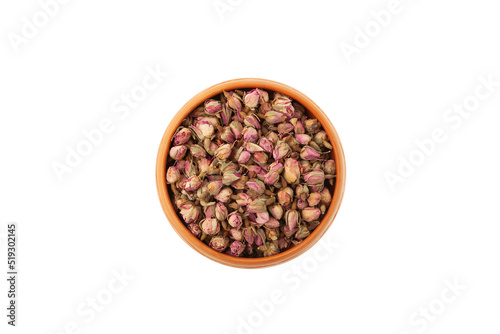 Dried rose buds in ceramic plate on white background, top view. Pink Rose buds used in herbal medicine and culinary as aromatic ingredient
