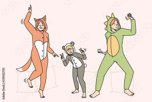 People in kigurumi pajamas have fun dancing indoors. Smiling adults and kid enjoying pyjama home party together. Leisure weekend. Vector illustration. 