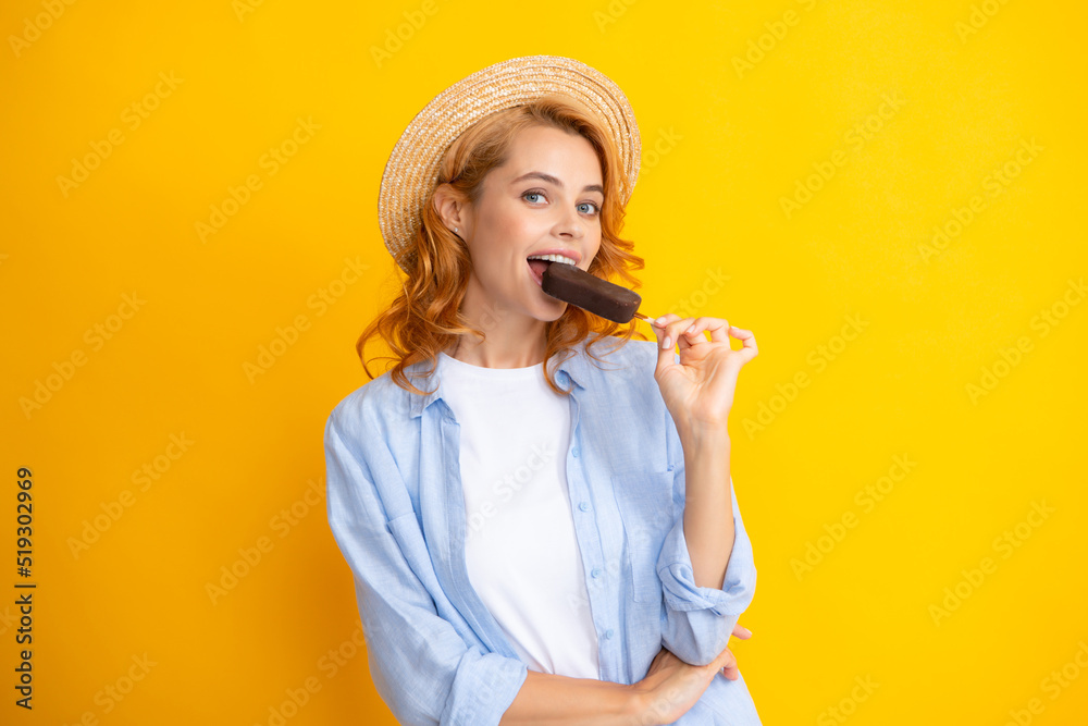 Fototapeta premium Portrait of cheerful funny teenage girl enjoys eating cold frozen dessert, eats delicious chocolate ice cream, yellow background.