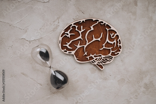 Wooden brain with hourglass. Top view. Concept of the transience of memory and intellect photo