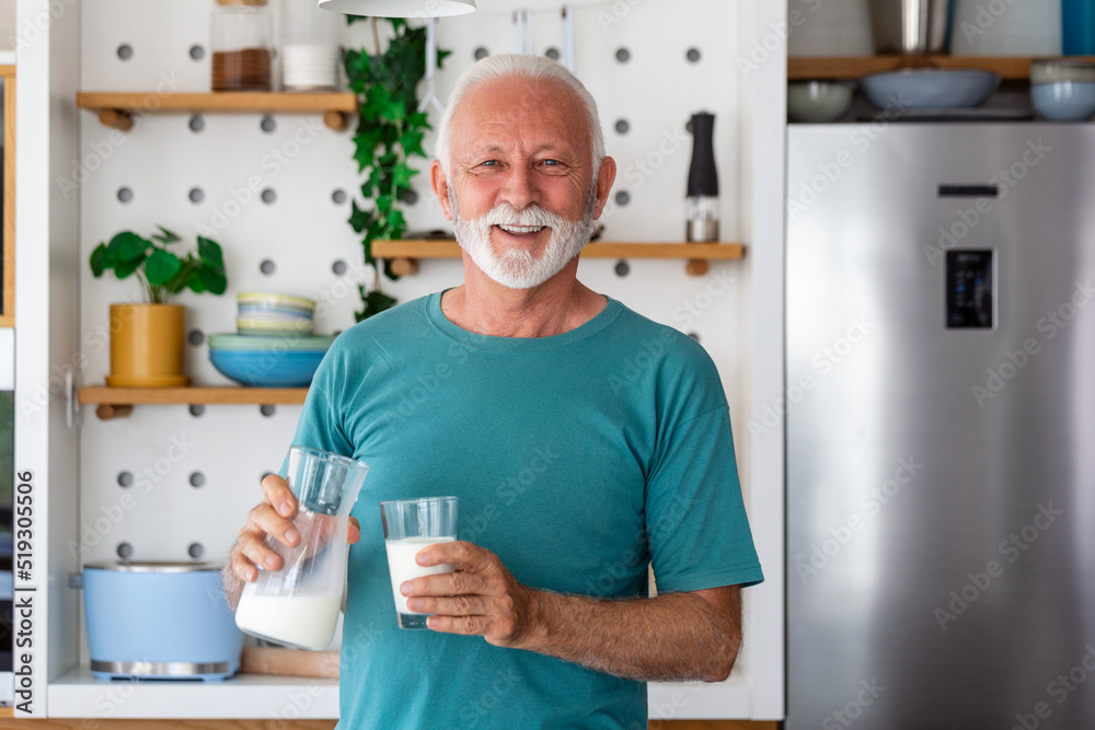 Senior man drinking a glass of milk with a happy face standing and smiling. Handsome senior man drinking a glass of fresh milk in the kitchen Senior man drinking a glass of milk with a happy face standing and smiling. Handsome senior man drinking a glass of fresh milk in the kitchen