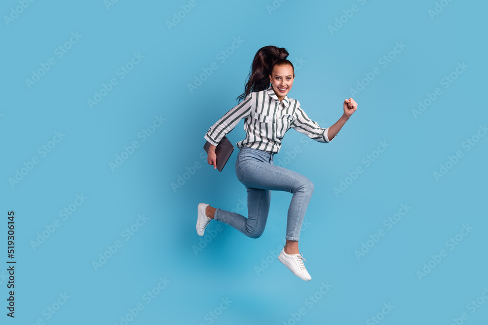 Full size photo of excited agent marketer jump run hold device isolated blue color background Full size photo of excited agent marketer jump run hold device isolated blue color background