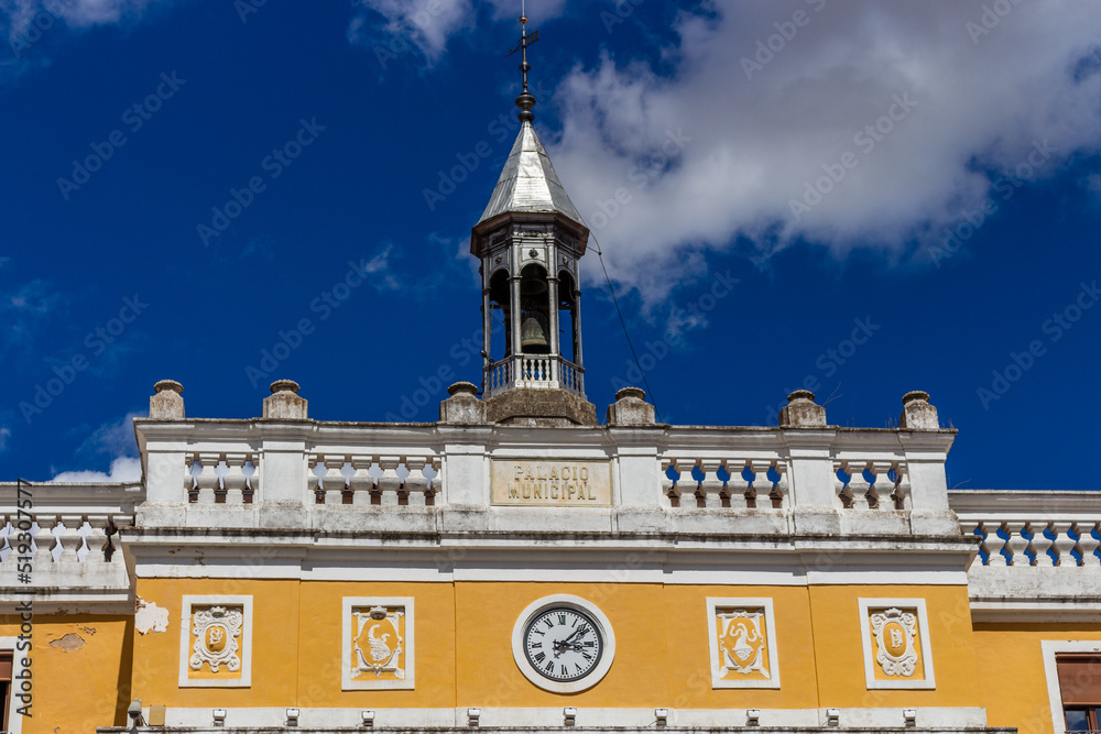 Badajoz, Spain, September 10, 2021: In the central Plaza España, opposite the statue dedicated to Luis Morales and the rear facade of Badajoz Cathedral, the Town Hall is a classical palace. Bell tower
