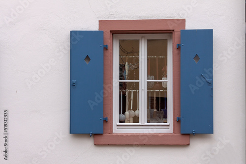 Fenster mit blauen Fensterläden und Küchenutensilien