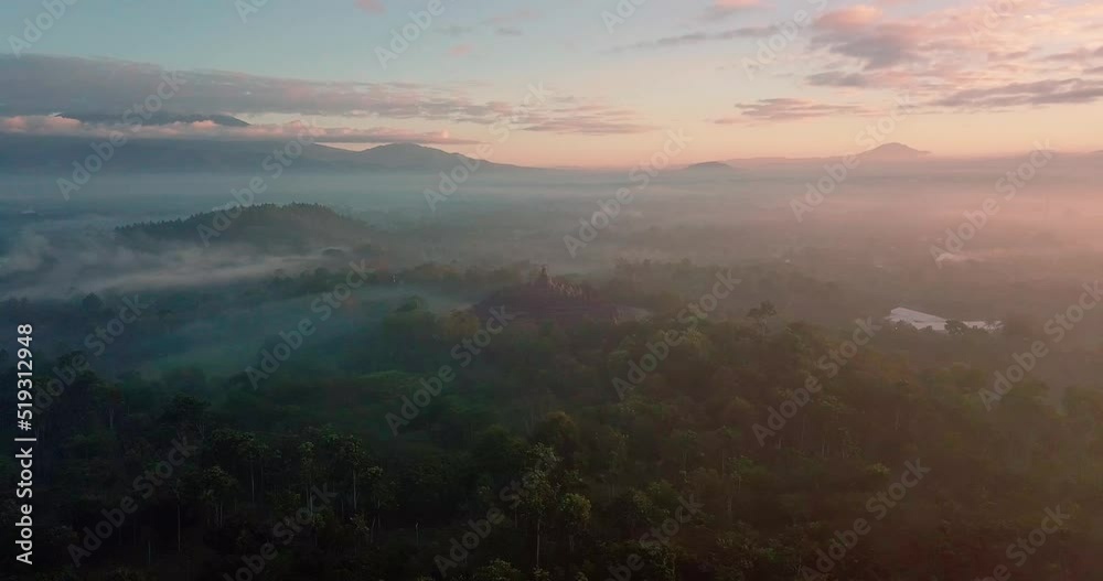Majestic Borobudur temple in sunrise time. Borobudur Temple in misty morning, thick fog with mountain view in the background. aerial drone shoot view of Mount Merapi from Punthuk Setumbu. Majestic Borobudur temple in sunrise time. Borobudur Temple in misty morning, thick fog with mountain view in the background. aerial drone shoot view of Mount Merapi from Punthuk Setumbu.