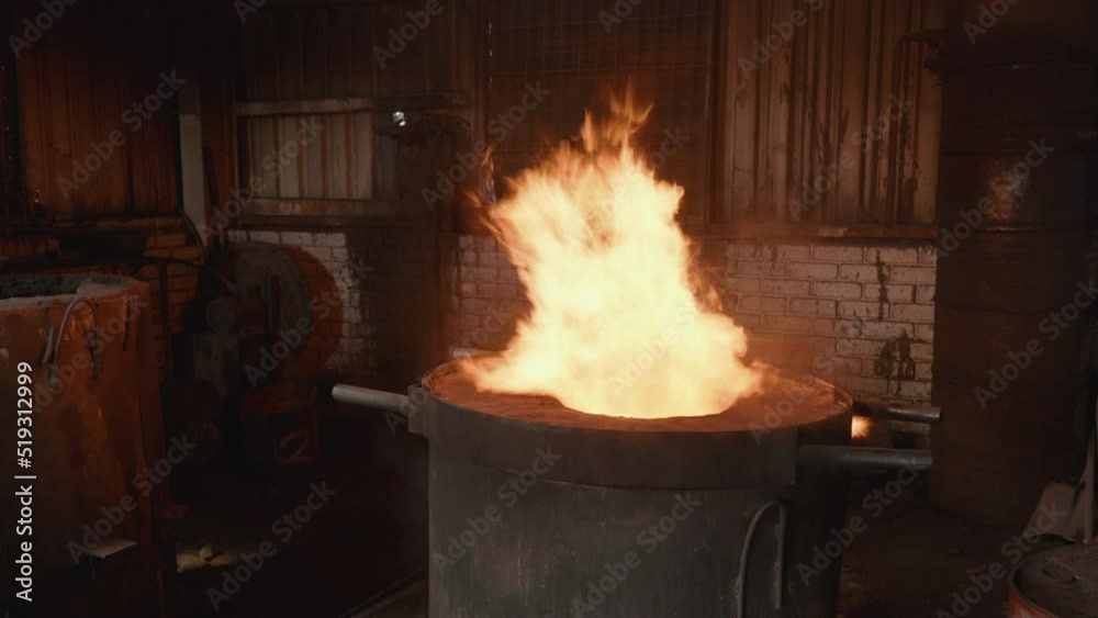 Realtime wide orbit of blazing red flaming furnace in small scale foundry workshop