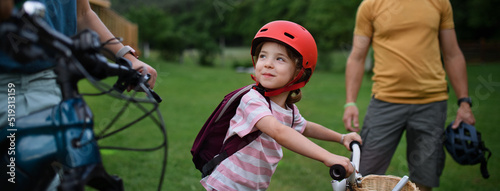 Young family with little children preaparing for bike ride, in front of house.