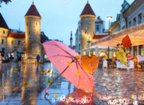 Autumn leaves rain in Tallinn old town rainy city wet pavement medieval houses people walk with umbrellas night light blurred on drops view from window glass vitrines defocus background